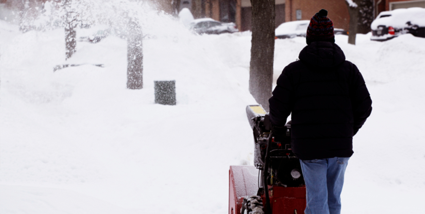 Person using a snow removal equipment on a snowy street