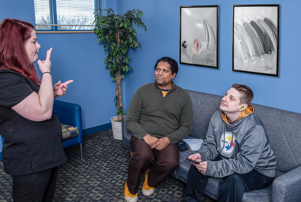 Doctor signs to two patients in waiting area