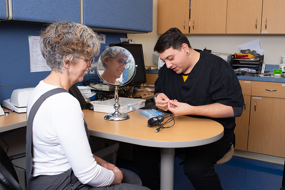 Audiologist shows patient hearing device