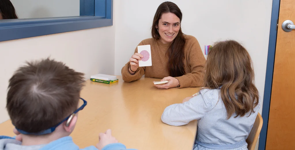 Speech therapist shows two students flash cards